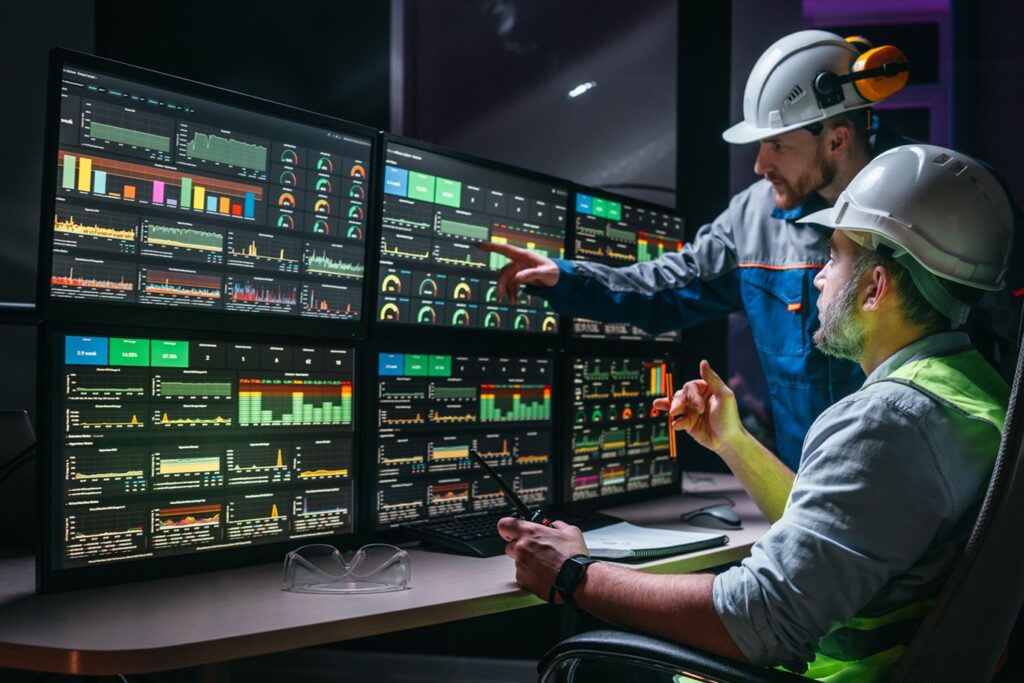 Operator monitorujący system SCADA na ekranach w zakładzie przemysłowym