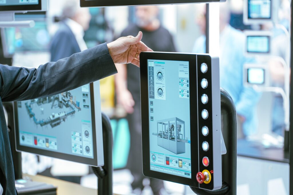 Inżynier automatyk monitoruje wskaźniki produkcji na ekranie systemu sterowania w ramach wdrożenia przemysłu 4.0